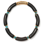 The Cathedral Collar by Lizzie Fortunato is a black horn beads necklace with curved segments, small turquoise stones, gold accents, and a gold clasp.