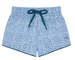 Minnow Boys' Starburst Boardie swim trunks featuring a light blue geometric starburst print, elastic waistband, and dark blue drawstring, laid flat on a white background.