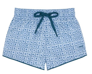Minnow Boys' Starburst Boardie swim trunks featuring a light blue geometric starburst print, elastic waistband, and dark blue drawstring, laid flat on a white background.
