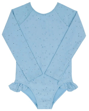 The Minnow Girls’ Eyelet Rashguard One Piece is a light blue, long-sleeve swimsuit featuring an eyelet pattern and ruffle hip detail, shown flat on a white background.