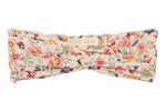The Julie Headband by Louise Misha is a floral-patterned cotton batiste turban headband with a stylish front twist and signature label.