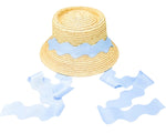 The Youth Harbor Hat by Bits & Bows is a woven straw beach hat with a wide, wavy light blue ribbon band and trailing ribbons, shown on a white background—ideal for stylish sun protection.
