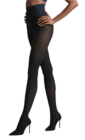 A person stands against a white background wearing Commando CDO Semi Opaque Tights, featuring a soft microfiber waistband, paired with black high-heeled shoes.