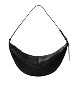 Proenza Schouler's Slide Bag is a black crescent-shaped leather shoulder bag with a minimalist design, featuring central visible stitching and an adjustable strap for versatile wear, ideal for any stylish outing.