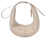 The Slide Bag by Proenza Schouler is a cream-colored, crescent-shaped leather handbag with a monogram detail, short strap, and zipper closure.