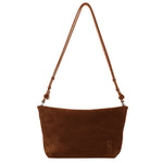 The Proenza Schouler Bond Suede Bag features brown suede, a single strap, minimal design, and a small embossed logo in the corner. Effortlessly worn as a crossbody for versatile style.