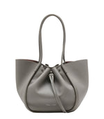 The Proenza Schouler Large Ruched Soft Pebbled Calf Tote in grey features a drawstring closure, two long handles, and comes with a matching leather zip pouch, all set against a plain white background.