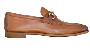 The Magnanni Diago Loafer is a brown leather bit loafer with metal bit detail, low heel, Línea Flex construction, and stitched accents, shown in side profile on a white background.