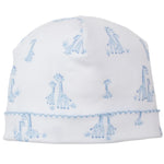 The Kissy Kissy Giraffe Grace Hat is a soft white Pima cotton baby hat with a light blue giraffe and grass print, accented by a charming blue stitched edge.
