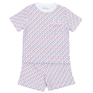 The Lila & Hayes Boys' Charles Short Set is a two-piece pajama made from soft Pima cotton, featuring short sleeves, shorts, and a white background with a red and blue star pattern.
