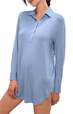 A person wearing the Eberjey Gisele Boyfriend Sleepshirt—a light blue, long-sleeve, collared shirt with a partial button placket and side slits—stands against a white background.