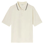 The Frame Light Pique Polo is a short-sleeve cream shirt crafted from cotton piqué, featuring a two-button placket and a collar with black double stripes—an everyday essential for any wardrobe.