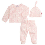 The Magnetic Me Baby Modal Kimono Take Me Home Set features a kimono wrap top, footed pants, and a knotted hat in pink and white animal print, all crafted from soft sustainable modal.