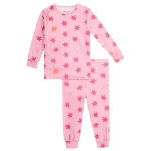 The Magnetic Me Baby Girls' and Girls' Cosmic Confetti Modal PJ Set features soft modal fabric, pink long sleeves, and matching pants with a vibrant red, pink, and orange star print for cozy comfort.
