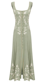The Mila Linen Dress by Lug Von Siga is a long green dress featuring a fitted bodice, floral embroidery, button-down front, bottom slit, sleeveless design with wide straps, and a square neckline.