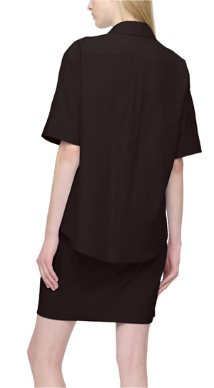 A person with long hair elegantly wears the Montana Dress, a black, short-sleeve shirt dress from Callas Milano, crafted from luxurious Italian Albini fabric, viewed gracefully from the back.