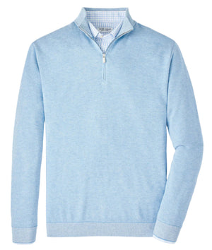 The Peter Millar Coolspun Cotton Quarter-Zip Sweater, in light blue with a white zip and a standing collar, offers breathable comfort. Ideal for layering over a blue and white checkered shirt for stylish appeal.