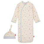 The Baby Organic Cotton Gown & Hat Set by Magnetic Me is a cream baby gown with gray trim and a matching knotted hat, made from organic cotton. It features small animal and nature prints, offering comfort and style for newborns.