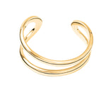 The Lie Studio Maggie Bracelet features a minimalist double band gold design, styled on a white background. This elegant cuff adds versatile sophistication to any outfit.