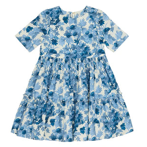 The Cara Cara Girls' Margaux Dress is a short-sleeved, knee-length A-line dress with a blue floral print on white and a gathered, tiered skirt.