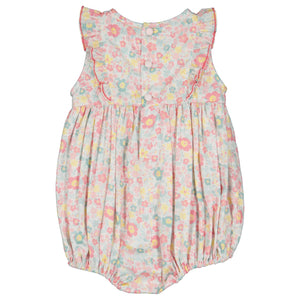 The Antoinette Baby Girls' Marguerite Floral Pink Frilled Sleeveless Smocked Romper features hand-smocked floral embroidery, ruffled shoulders, and gathered fabric, complete with two buttons at the back.