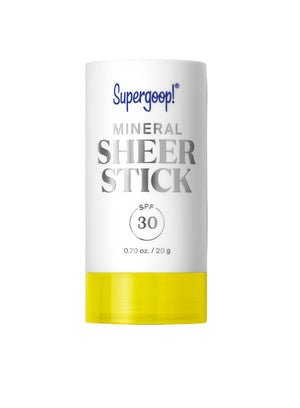 A white and yellow tube labeled "Supergoop Mineral Sheer Stick SPF 30" (0.70 oz/20 g) rests on a white background, showcasing this convenient sheer sunscreen for easy sun protection.