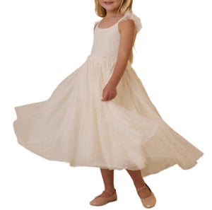 A young girl twirls in a Noralee Girls' Poppy Dress featuring long, flowing fabric and delicate floral embroidery, paired with flat shoes.