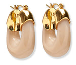 The Organic Gold Hoops by Lizzie Fortunato are beige resin chunky hoop earrings featuring shiny gold-tone hardware at the top.