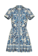 The Noor Mini Dress by Cara Cara features short sleeves, a collared design, blue and white floral and geometric patterns, a fitted waist with subtle darts, and a flared skirt for a fresh, charming look.