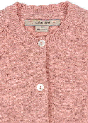 Close-up of the Baby Girls' and Girls' Cypres Cardigan by Konges Slojd, featuring soft pink knitted cotton, a "Konges Sløjd, 3Y, made in India" label, and two delicate mother of pearl buttons.