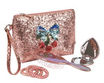 The Konges Slojd Get Ready With Me Set includes a glittery pink cosmetic clutch with sequin bow and cherries, a pink hair brush, coiled hair ties, and a heart-shaped hand mirror for quick touch-ups anywhere.