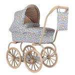 The Konges Slojd Minnie Doll Pram features a vintage style with quilted floral print fabric, a beige frame, large spoked wheels, foldable sun canopy, and a matching bag hanging from the handle.