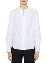 A person wearing a Callas Milano Olympia Top with a feminine structure and black pants stands against a plain background.