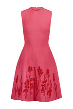 The Penelope Floral Knit Mini Dress by Lela Rose is a sleeveless, knee-length pink dress with a fitted bodice, flared skirt, and red floral embroidery along the lower half.