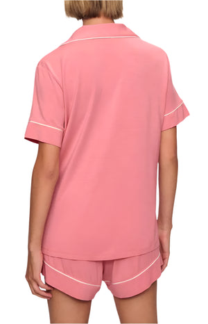 Someone is seen from the back wearing Eberjey's Gisele Relaxed Short PJ Set, a pink pajama set with white trim.