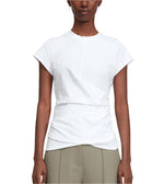 A person wears a 3.1 Phillip Lim Draped SS T-Shirt, a short-sleeve white top with subtle pleats and an asymmetric neckline, paired with high-waisted light olive green tailored trousers.