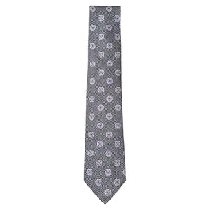 The Starburst Tie by Robert Jensen is a gray silk tie, hand-stitched in Italy, featuring a small checkered pattern with repeating white and blue circular floral motifs.