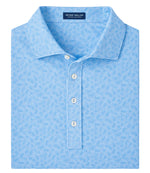 The Peter Millar Avenue Performance Jersey Polo is a folded light blue patterned collared shirt with UPF 50+ protection, featuring an inner collar label and three white buttons on the placket.