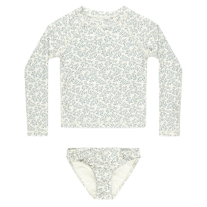 The Rylee & Cru Baby Girls' and Girl's Maryn Rashguard Set is a two-piece swim set with a white and blue floral design, UPF 50+ sun protection, including a long-sleeve top and bikini bottoms—perfect for safe fun at the beach or pool.