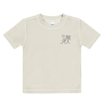 The Rylee & Cru Boys' Rashguard is a beige short-sleeve tee with a wave, palm tree, and sun graphic on the left chest. It offers UPF 50+ sun protection, making it perfect for beach or pool play.