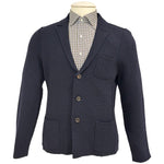 The Alan Paine Rudston Cardigan features a tailored fit in navy blue with a textured finish, three buttons, patch pockets, and a notched lapel, displayed over a buttoned checkered shirt on a mannequin.