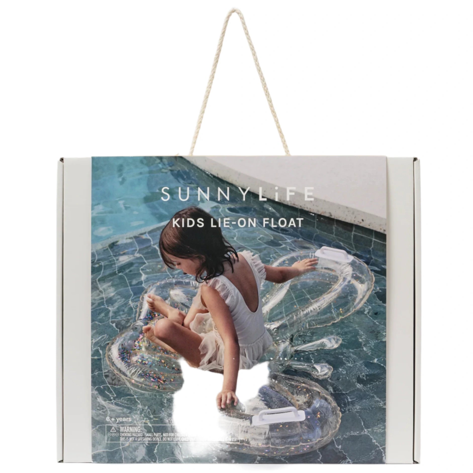 A child sits on the Kids' Lie-On Float Cotton Candy Glitter by Sunnylife in a sparkling swimming pool. The packaging reads "Sunnylife Kids' Lie-On Float Cotton Candy Glitter.