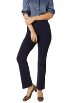 Someone wearing a denim shirt, Ann Mashburn's Faye Flare Cropped Ponte Knit Pant, and leopard-print shoes stands against a plain background.