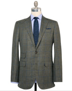 The Sid Mashburn Virgil No. 2 Jacket in green plaid silk-linen with notch lapels and spalla camicia construction is styled on a mannequin with a light blue dress shirt and a navy tie with white dots.