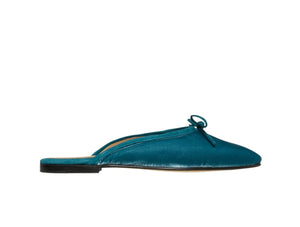 Ann Mashburn's Joy Velvet Mule, crafted in Italy, features a teal satin exterior, a black sole, and a delicate bow on top, shown from the side.