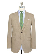 The Sid Mashburn Kincaid No.2 Jacket in beige Italian hopsack is shown on a mannequin with a light blue dress shirt and a green patterned tie.