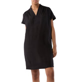 A person models the Ann Mashburn Libby Dress, a short-sleeve, knee-length black V-neck design, standing against a plain background.