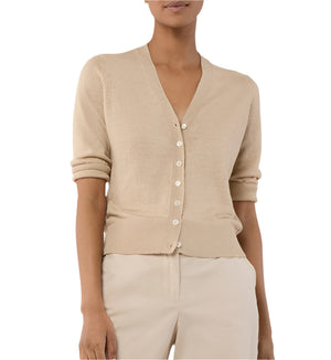 A person models the Ann Mashburn Rosie Cardigan—a beige V-neck, button-up sweater with rolled sleeves—paired with matching beige pants, shown from shoulders to hips.