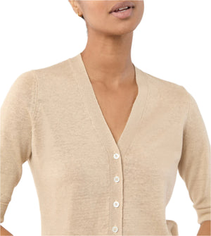 A person wears the Ann Mashburn Rosie Cardigan, a lightweight linen piece with a flattering V-neckline and white buttons, shown from shoulders to chest against a white background.