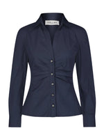 The Savile Top by Callas Milano is a dark blue, long-sleeved button-up shirt with a tailored silhouette, collar, and gathered front detail. Made from cotton poplin for style and comfort.